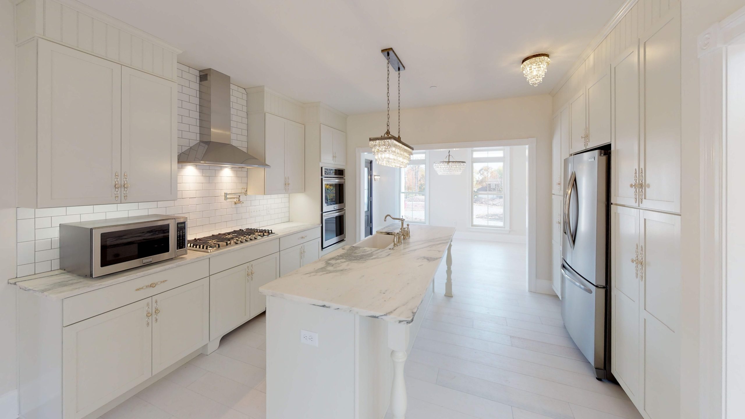 finished custom kitchen with white marble and silver details